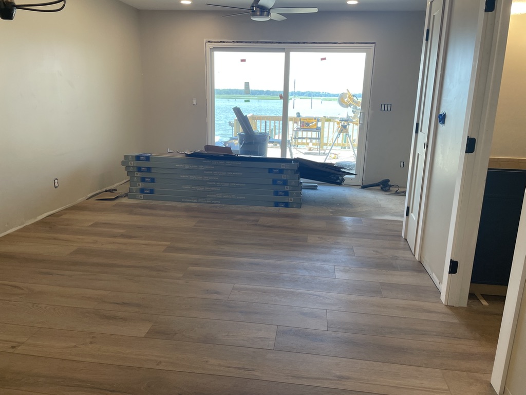 Living room renovation in progress at 4102 Channel Lane, with new flooring and waterfront view